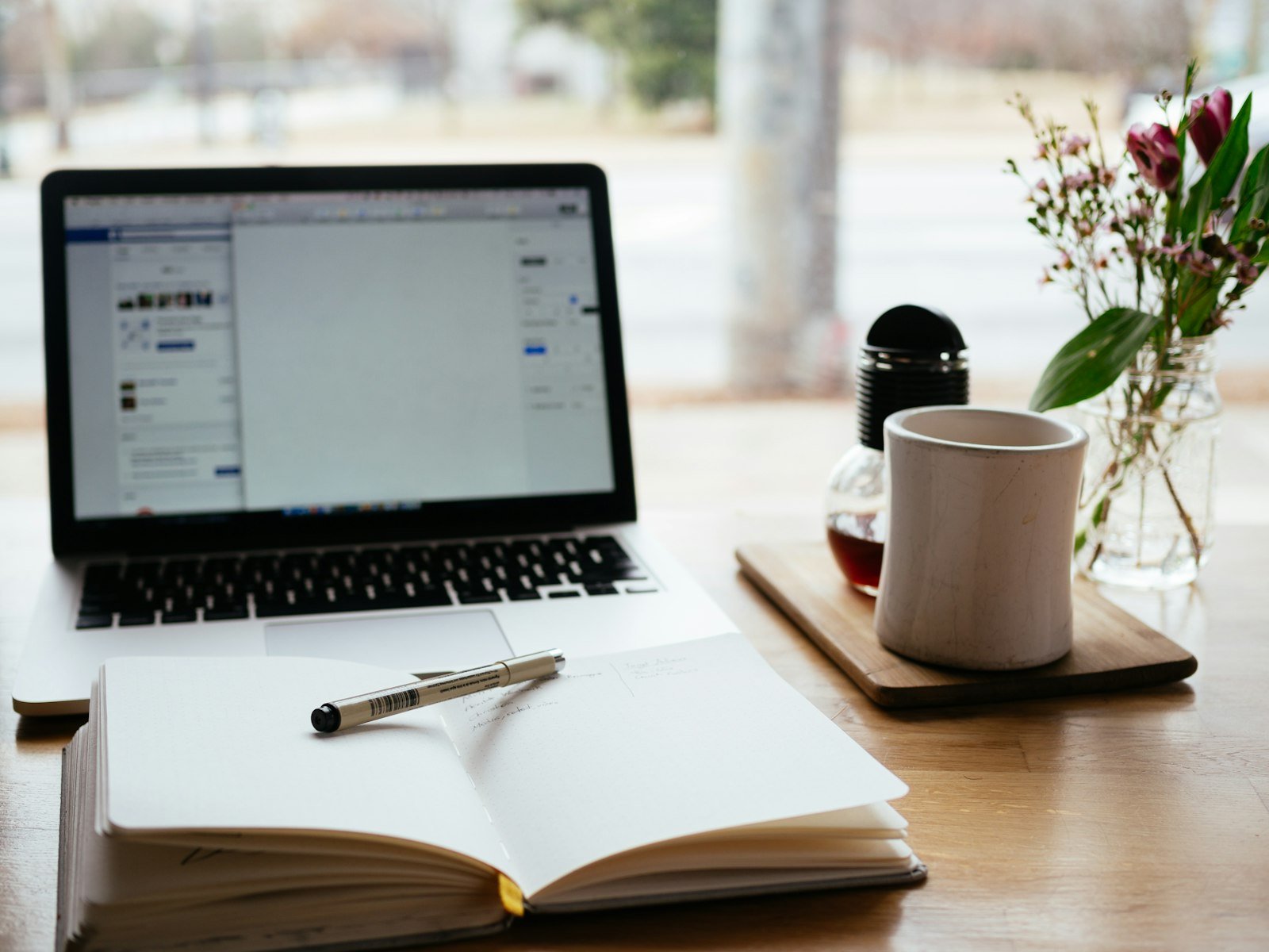 Laptop and open notepad on a desk for planning an SEO content brief