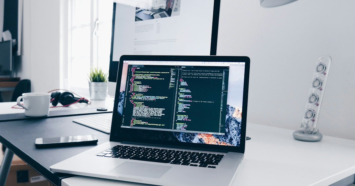 Laptop on a desk displaying website code